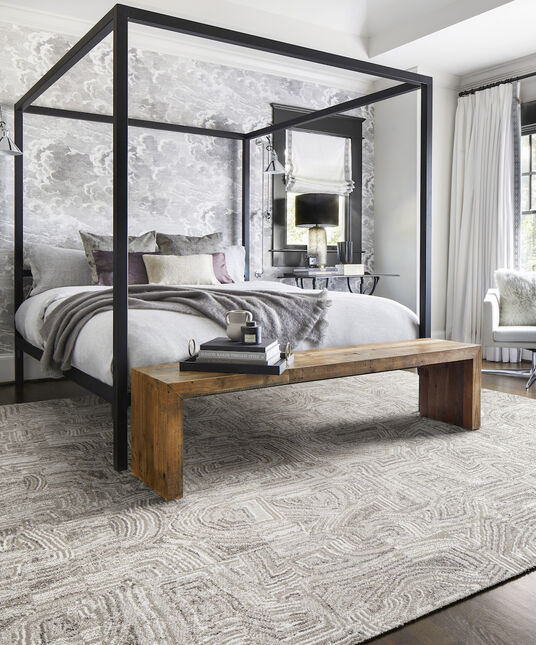 FLOR Anthracite bedroom rug in Chalk/Silver with a modern canopy bed and wood end table. 